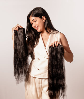 Person with long, straight hair extensions on a plain background
