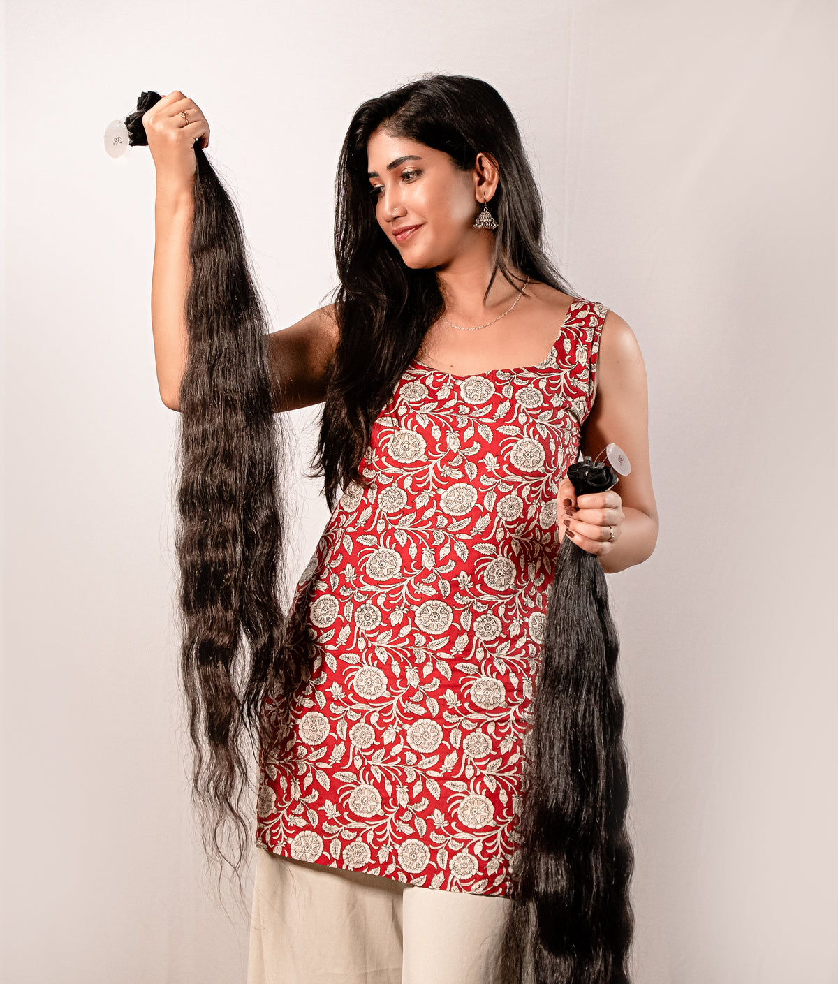 Woman holding a bundle of long Bridal Look Hair Extensions against a plain background.